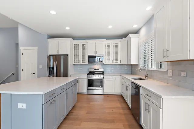 a kitchen with kitchen island granite countertop a sink stove oven and refrigerator