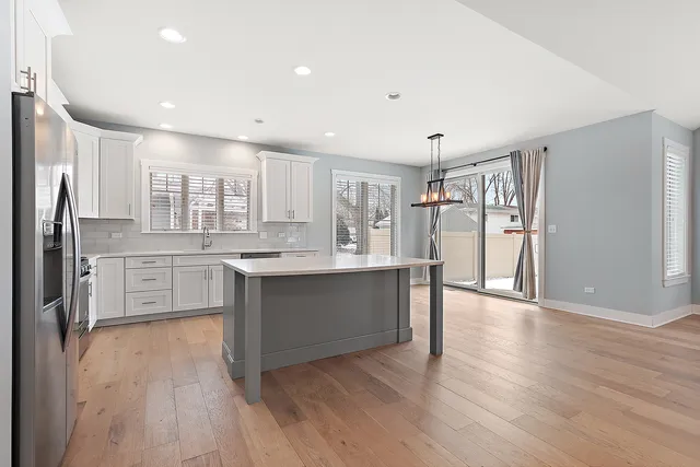 a large kitchen with cabinets wooden floor and stainless steel appliances