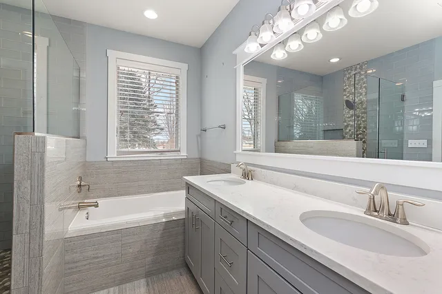 a bathroom with a granite countertop sink mirror bathtub and shower