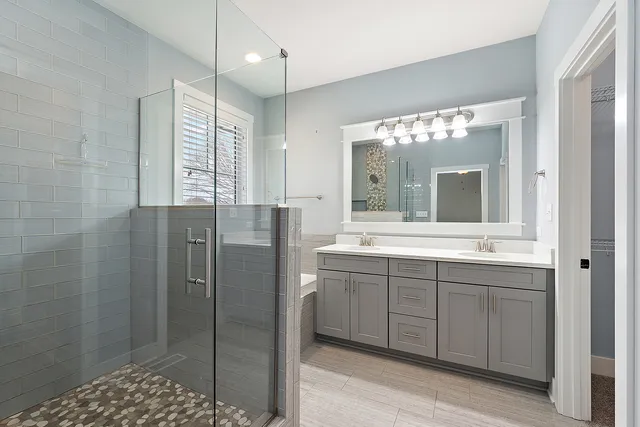 a bathroom with a double vanity sink mirror and shower