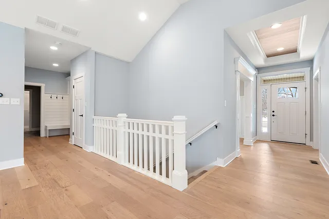 a view of a hallway with wooden floor and entryway