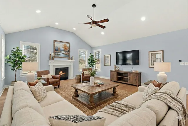 a living room with furniture a fireplace and a flat screen tv