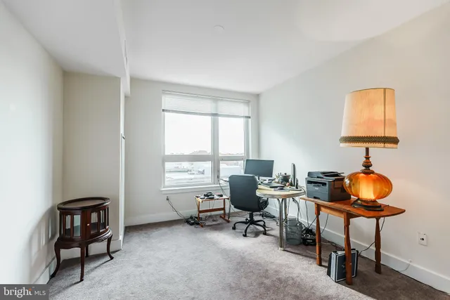 a view of a workspace with furniture and a window