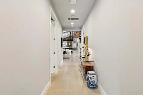 a hallway with wine table and a living room