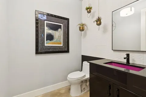 a bathroom with a toilet a sink and mirror