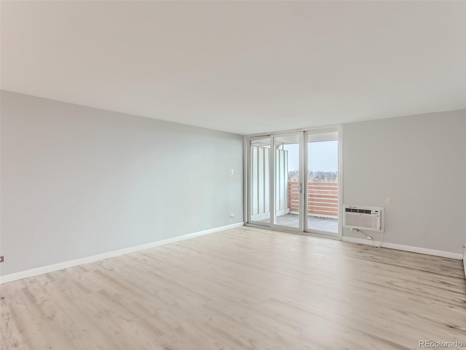 1029 East 8th Avenue, Unit 502 Denver, CO 80218 - Photo 11 of 26 a view of an empty room with wooden floor and a window