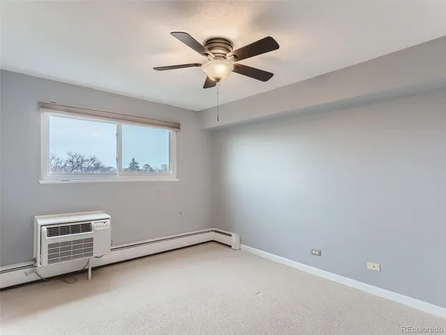 an empty room with windows and ceiling fan