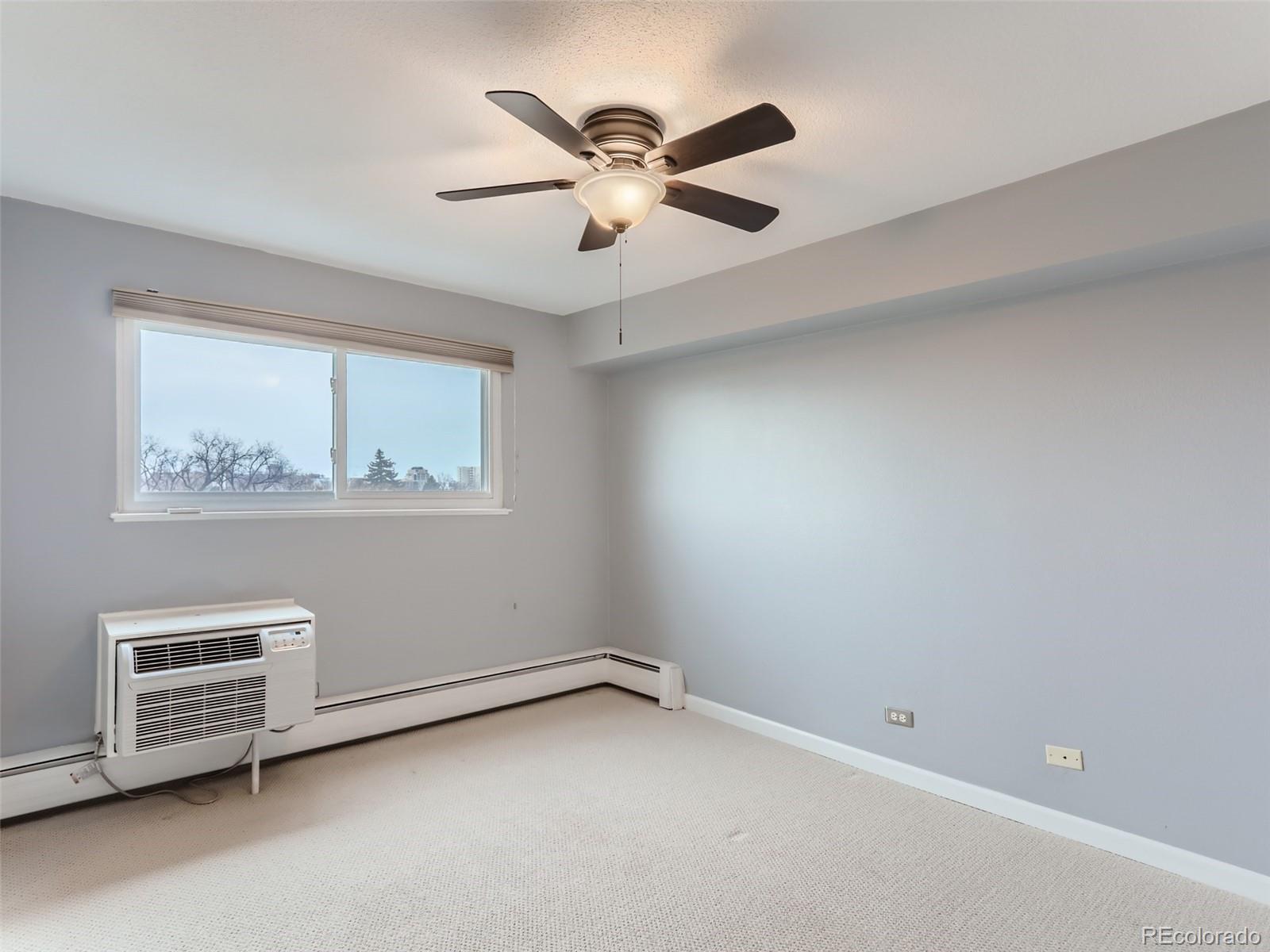 1029 East 8th Avenue, Unit 502 Denver, CO 80218 - Photo 15 of 26 an empty room with windows and ceiling fan