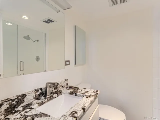 a bathroom with a sink vanity mirror and toilet