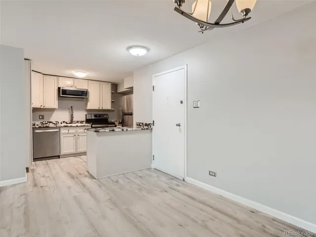 a kitchen with granite countertop white cabinets and appliances