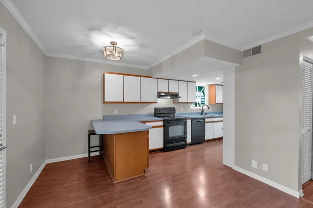 a kitchen with a sink cabinets and wooden floor