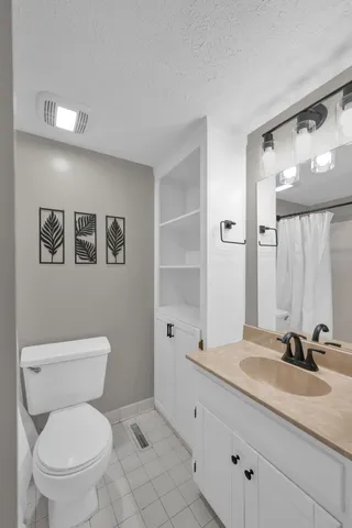 a bathroom with a granite countertop sink mirror and toilet