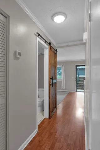 a view of a hallway with wooden floor and closet area