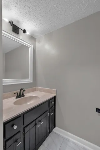 a bathroom with a sink vanity and a mirror