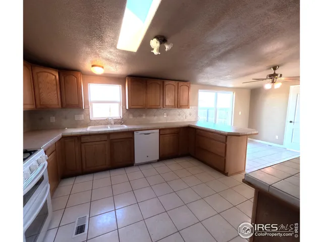 a kitchen with stainless steel appliances granite countertop a sink counter space cabinets and a window