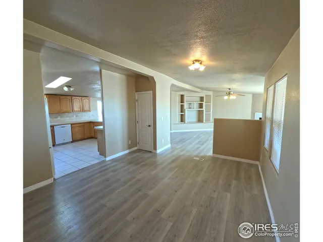 a view of a big room with wooden floor and windows
