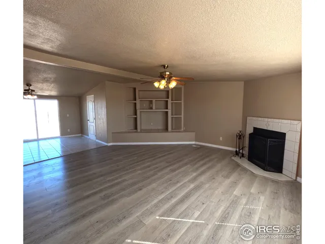 a view of empty room with wooden floor and fireplace