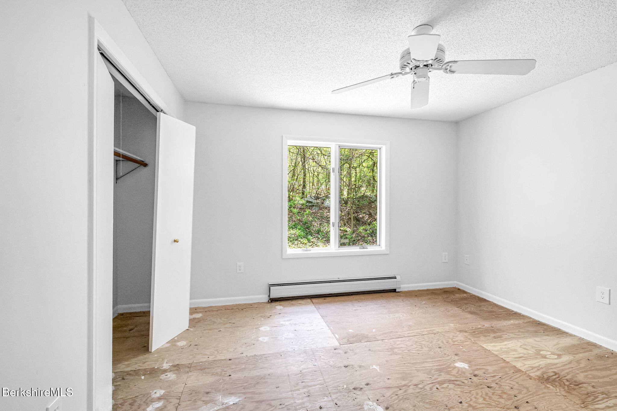 1874 Home Road Sheffield, MA 01230 - Photo 29 of 42 an empty room with windows and chandelier fan
