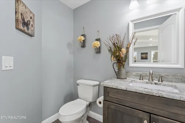 a bathroom with a granite countertop toilet sink and mirror