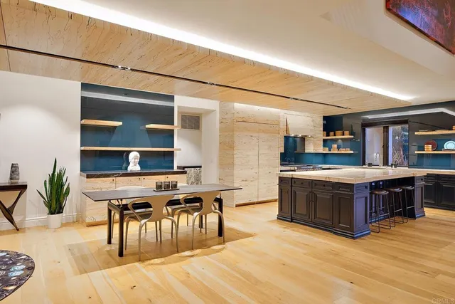 a kitchen with stainless steel appliances granite countertop a stove a sink a dining table and chairs