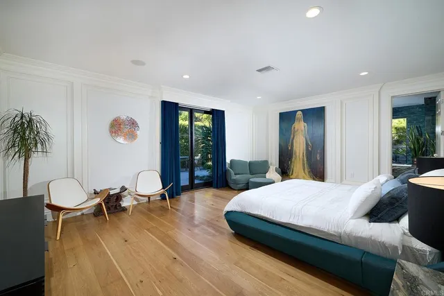 a living room with a bed furniture and large windows