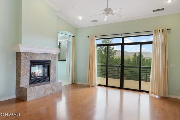 wooden floor fireplace and windows in an empty room