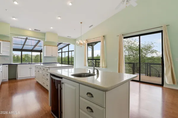 a kitchen with center island wooden floor and stainless steel appliances