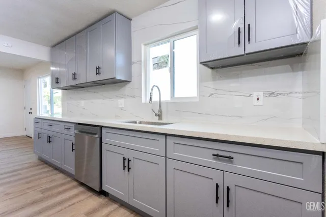 a kitchen with cabinets appliances a sink and a window
