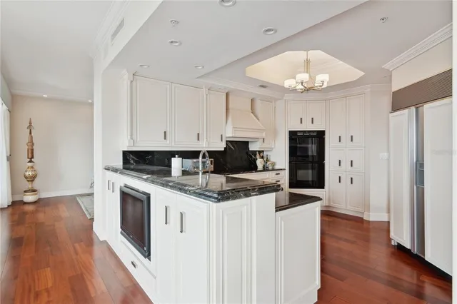 a kitchen with white cabinets and sink