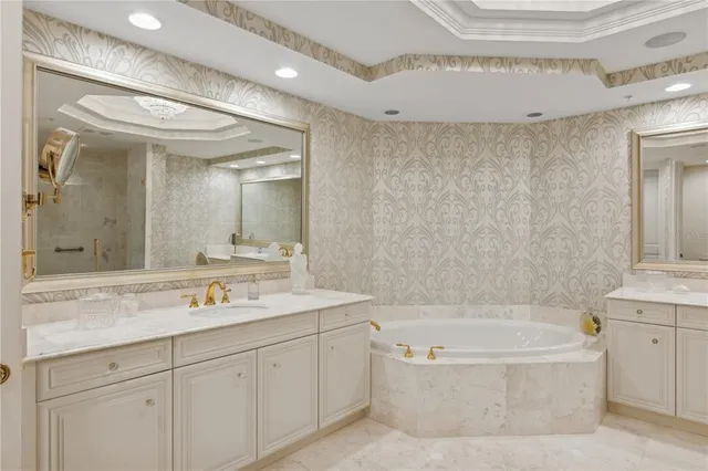 a bathroom with a sink mirror vanity and bathtub