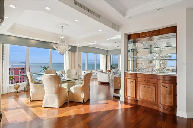 a dining room with furniture a chandelier and wooden floor
