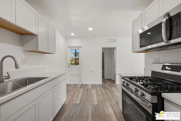 a kitchen with stainless steel appliances granite countertop a sink stove and refrigerator