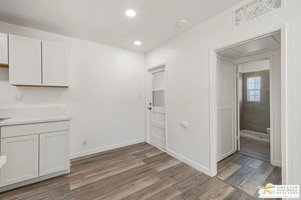an empty room with wooden floor and cabinet