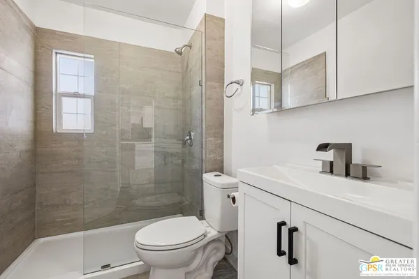 a bathroom with a sink a toilet and shower