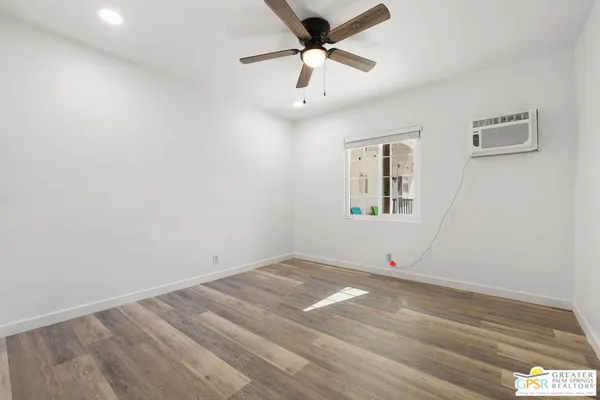 an empty room with a window and a ceiling fan