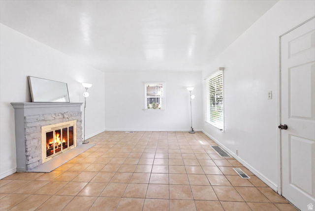 676 South 500 West Provo, UT 84601 - Photo 4 of 29 Unfurnished living room featuring a fireplace and light tile patterned flooring