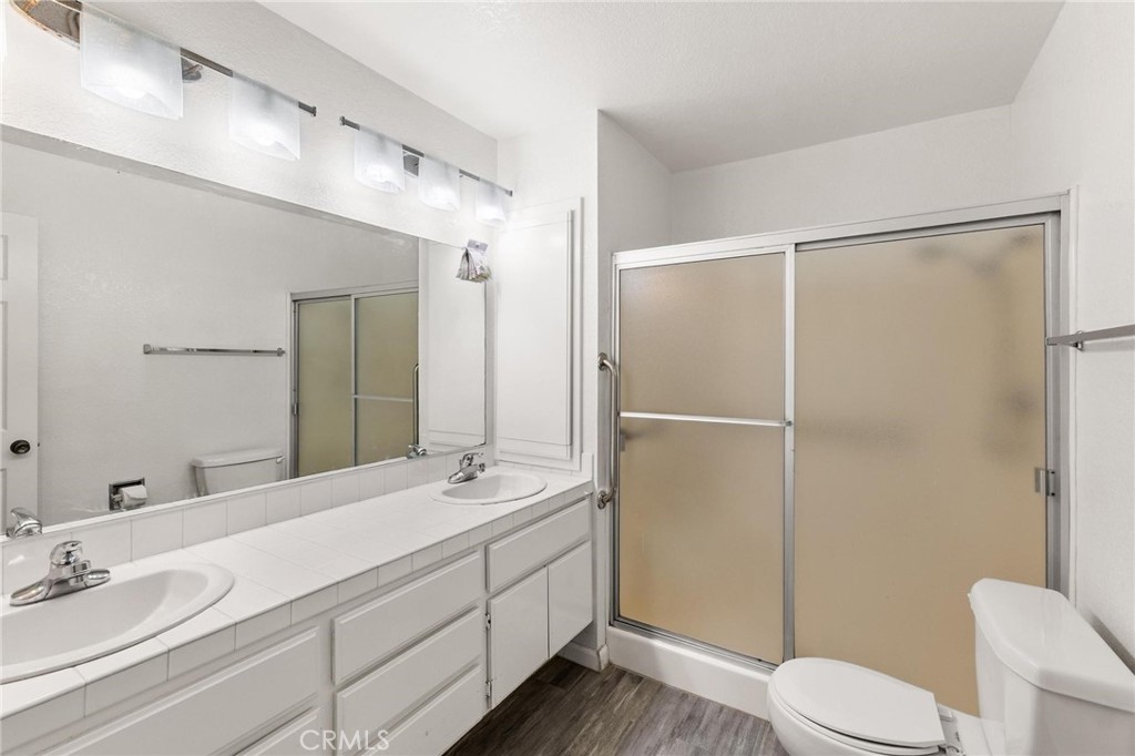 1076 Occidental Circle Redlands, CA 92374 - Photo 11 of 28 a bathroom with a double vanity sink toilet mirror and shower