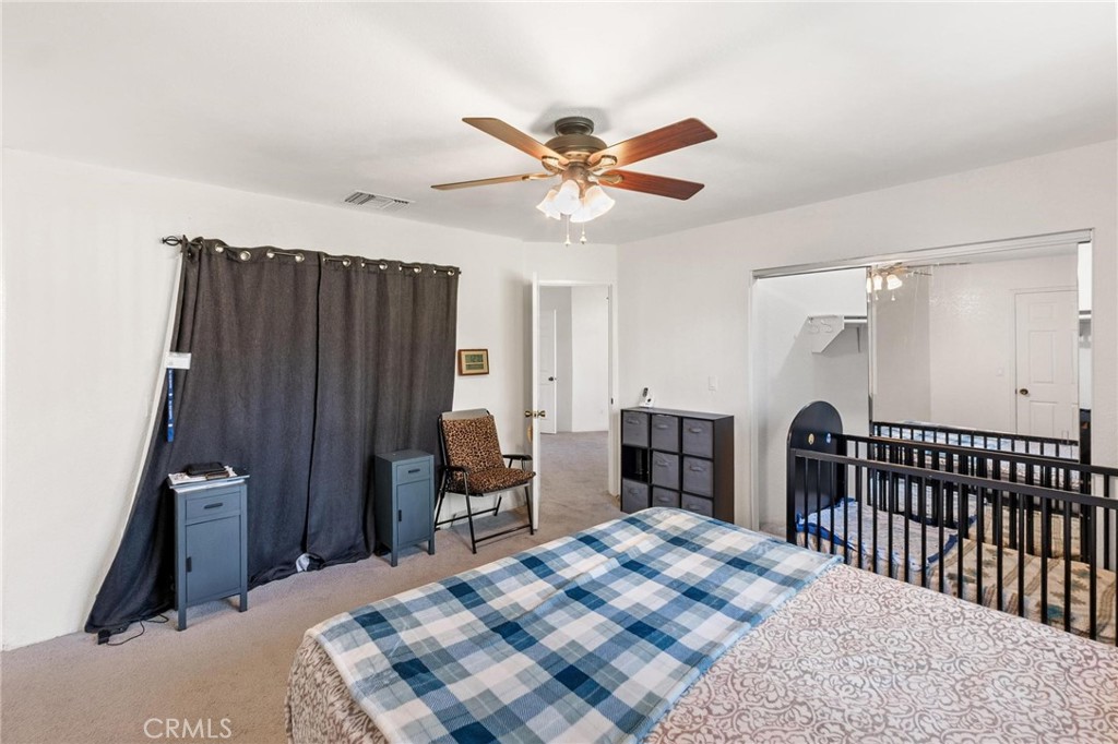 1076 Occidental Circle Redlands, CA 92374 - Photo 12 of 28 a bedroom with a bed and a chandelier