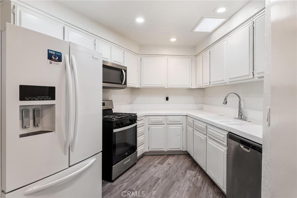1076 Occidental Circle Redlands, CA 92374 - Photo 21 of 28 a kitchen with stainless steel appliances granite countertop white cabinets a sink a stove and a refrigerator
