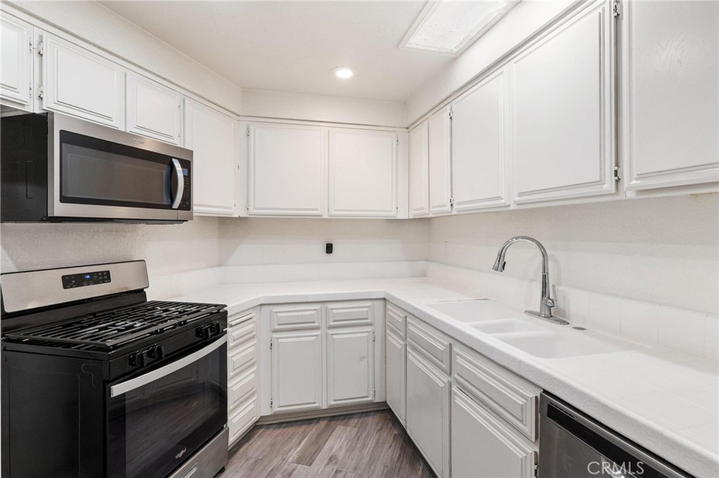 1076 Occidental Circle Redlands, CA 92374 - Photo 22 of 28 a kitchen with stainless steel appliances granite countertop grey cabinets a sink stove and microwave