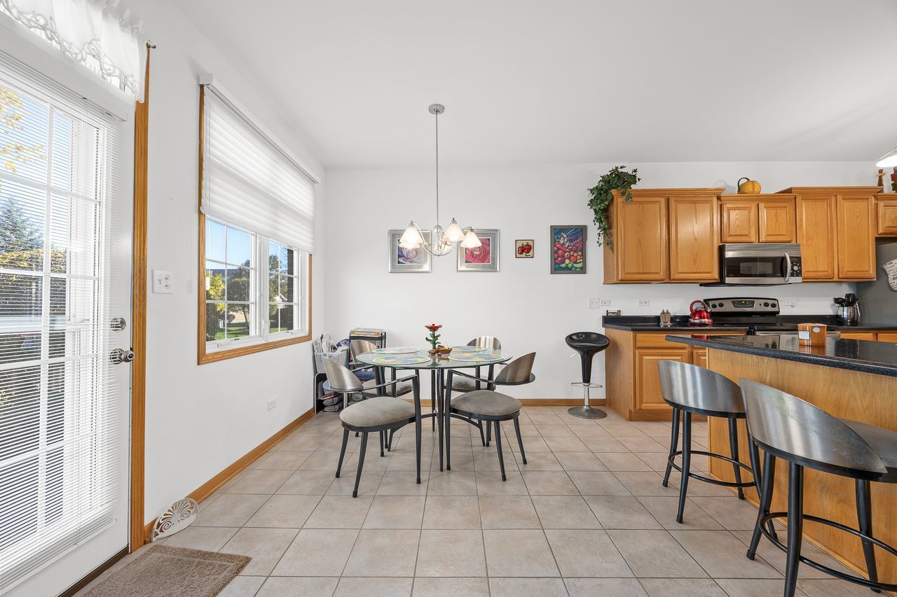 1343 Camelot Lane Lemont, IL 60439 - Photo 17 of 37 a dining room with furniture and a window