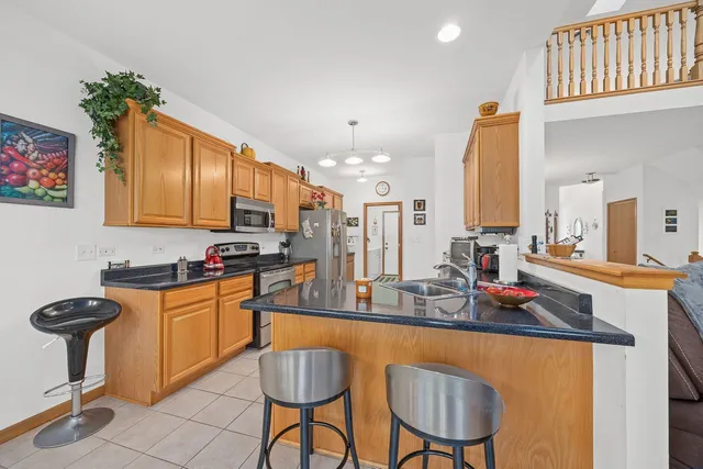 a kitchen with stainless steel appliances granite countertop a stove a sink and a refrigerator