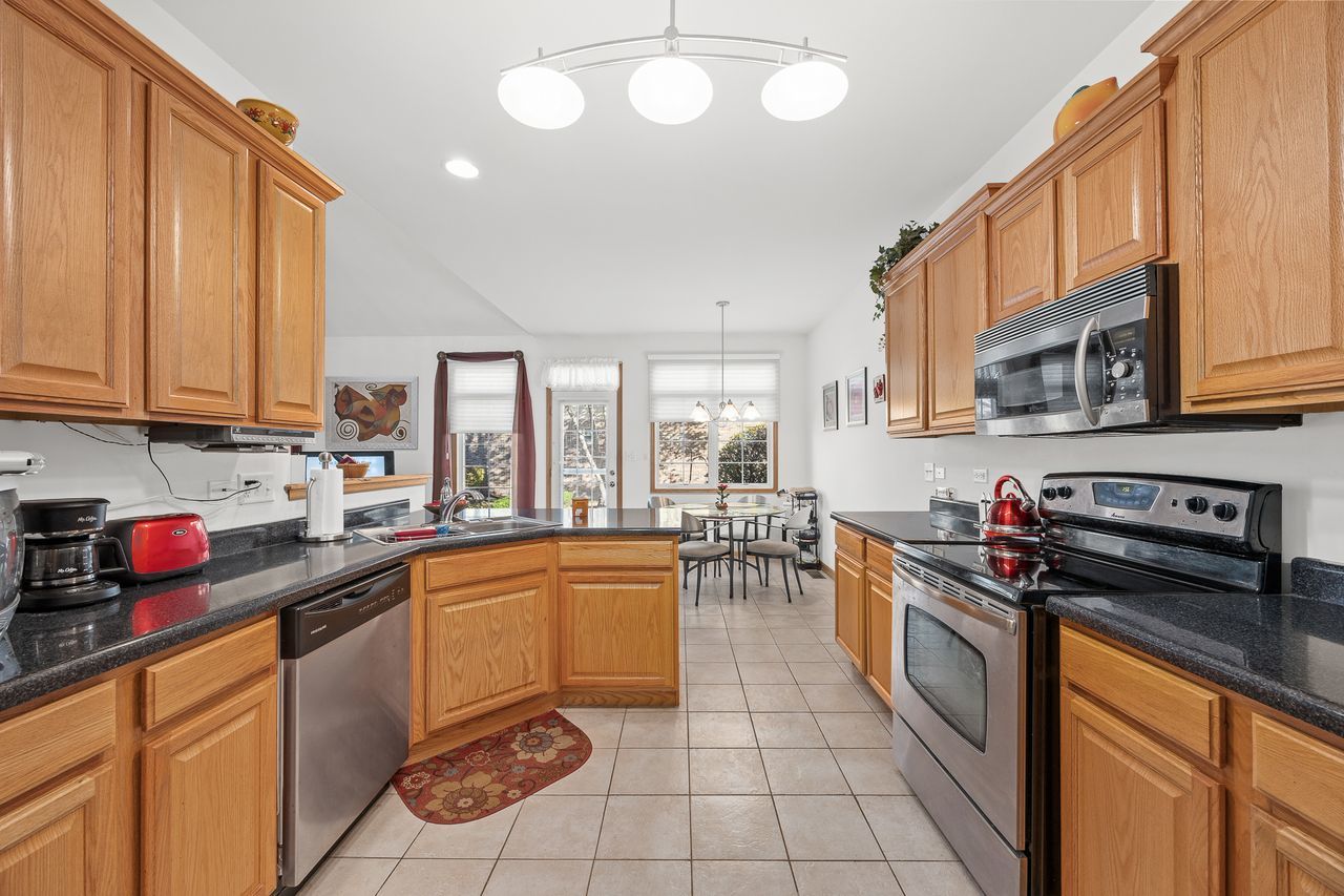 1343 Camelot Lane Lemont, IL 60439 - Photo 20 of 37 a kitchen with stainless steel appliances a sink stove and cabinets
