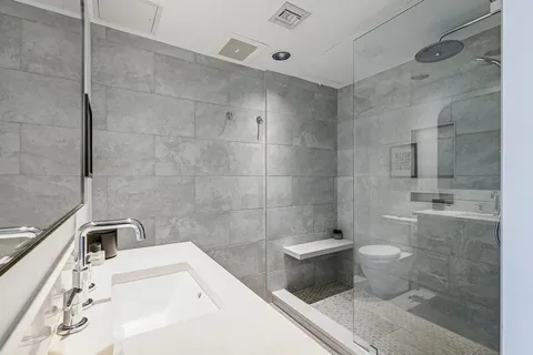 a bathroom with a sink a toilet and shower