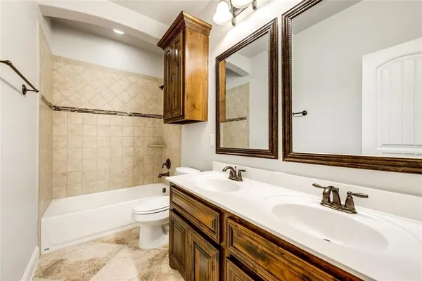 a bathroom with a granite countertop sink a toilet and a bathtub
