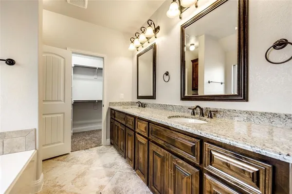 a bathroom with a granite countertop sink a large mirror and a shower