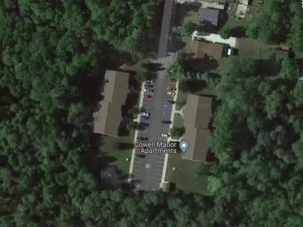 an aerial view of residential house with outdoor space and trees all around