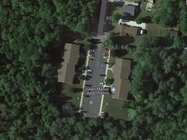 an aerial view of residential house with outdoor space and trees all around
