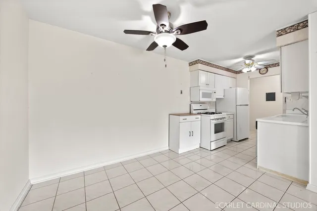 a kitchen with white cabinets a sink a stove and a window