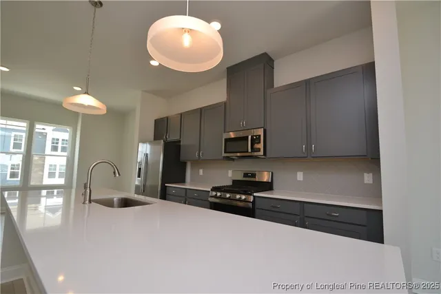 a kitchen with stainless steel appliances granite countertop a stove a sink dishwasher and a refrigerator